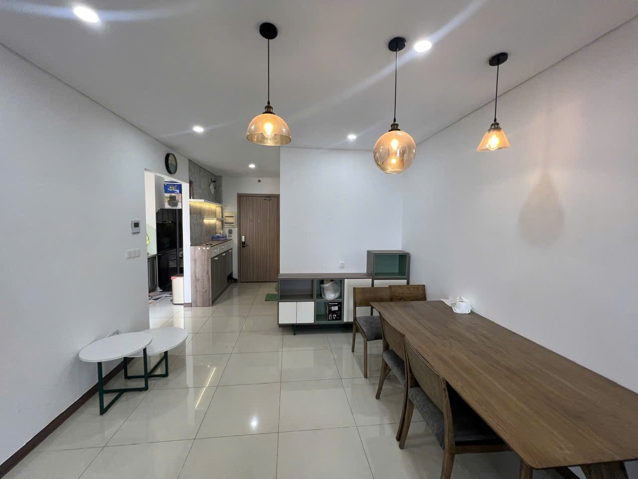 Phòng ngủ chính có giường đôi, đầu giường xanh và cửa sổ với rèm tối màu
